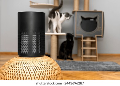 air purifier in the area with pets or cat. Air Pollution Concept. Air purifier, filters out invisible viruses, allergens or pollutants in the house on a cat tree background. Cute cat and Air purifier