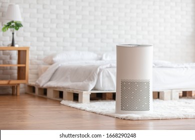 Air purifier in cozy white bedroom for filter and cleaning removing dust PM2.5 HEPA and virus in home,for fresh air and healthy Wellness life.Health care Air Pollution Concept