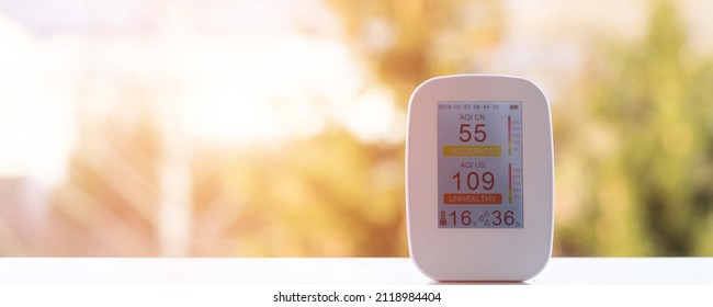 Air Quality Meter On The Windowsill Shows Poor Quality At Sunrise In The Early Morning. Air Quality Tester For Air Quality For Measuring Humidity, Temperature And Air Purity. Poor Monitor