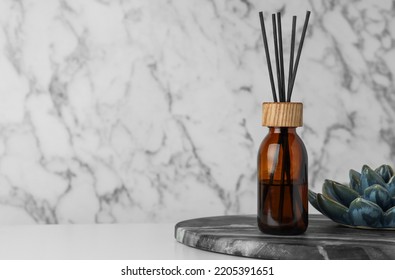 Air Reed Freshener And Ceramic Decor On Table Near Marble Wall. Space For Text