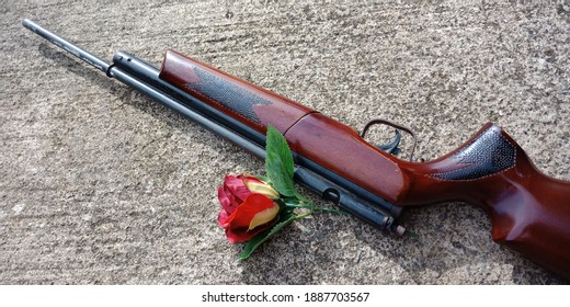 Air Rifle And Rose Lying On The Mossy Floor