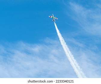 Air show of the Frecce Tricolori aerobatic team of the Italian Air Force with smoke trail in front of partly clouded sky