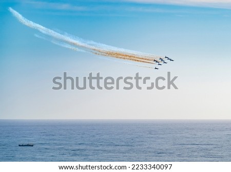 Air show of the Frecce Tricolori aerobatic team of the Italian Air Force with colored smoke trails over open sea