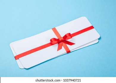 Air tickets as a gift with a red ribbon and bow.