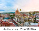 Air tour over the beautiful Parroquia de San Miguel Arcángel surrounded by beautiful colorful houses in the magical town of San Miguel de Allende