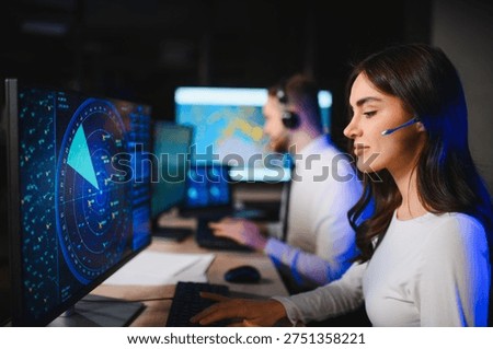 Air traffic controllers using headsets and a computer radar screen, focused on safely guiding aircraft in the control center