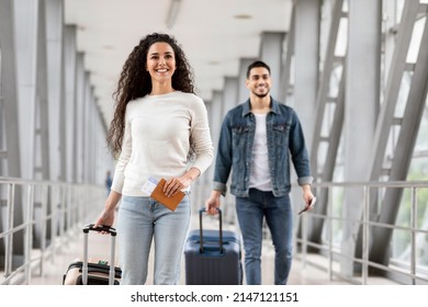 Air Travels Concept. Portrait Of Happy Man And Woman Walking With Suitcases In Airport, Smiling Arab Male And Female Going With Luggages To Departure Gate, Enjoying Travelling, Copy Space - Shutterstock ID 2147121151