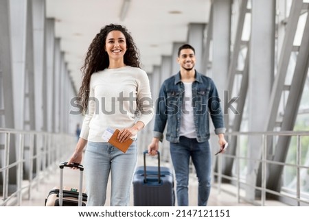 Air Travels Concept. Portrait Of Happy Man And Woman Walking With Suitcases In Airport, Smiling Arab Male And Female Going With Luggages To Departure Gate, Enjoying Travelling, Copy Space