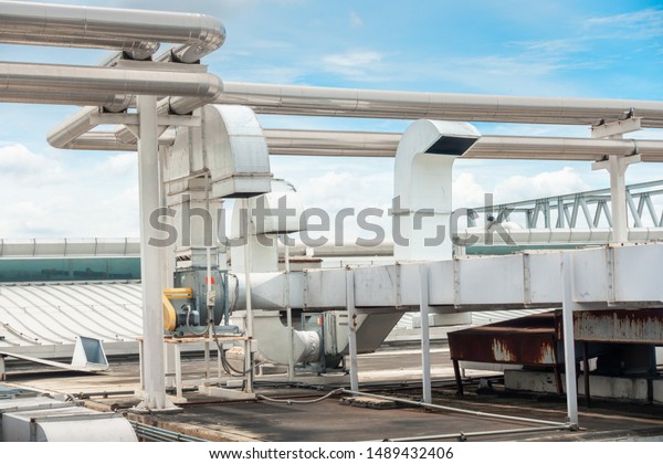 Air Ventilation Exhausting Blower and Chiller\
Pipe on Roofing Floor of Manufacturing Power Plant. Building\
Structure of Air Conditioning Chiller Pipeline and Outlet Vent Duct\
Hood for HVAC System.