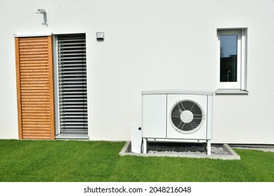 Luft-Luft-Wärmepumpe für Heiz- und Warmwasser vor einem neuen Wohngebäude