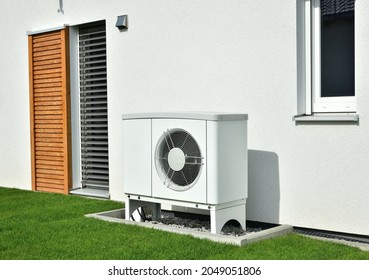 Air-Air Heat Pump for Heating and hot Water in Front of an new built Residential Building - Shutterstock ID 2049051806