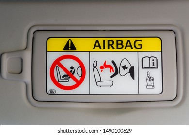 An Airbag Safety Sign On The Sun Visor Of A Car.