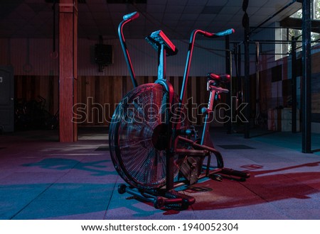 Airbike, professional exercise bike with aerodynamic loading system in red-blue neon light in a modern health class.