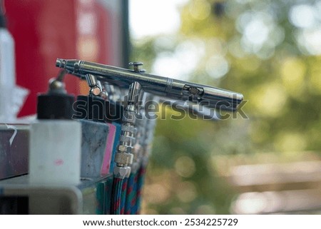 Airbrush tools lined up at a creative workspace during a sunny afternoon in a vibrant studio