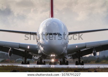 Airbus A380 jumbo airliner in front view on runway.