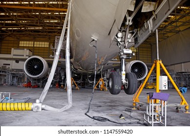 Aircraft (airplane) lift up from the floor by aircraft jack for maintenance at aircraft hangar.Aircraft on jack in hangar for maintenance service check by mechanic.