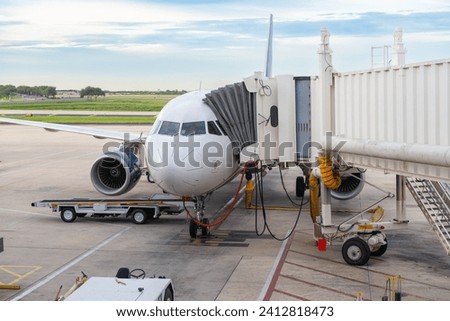 an aircraft being refueled and serviced at the airport