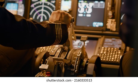 Aircraft captain in cockpit command taking off with airplane, throttling power engine lever to navigate radar compass. Airline service to fly plane with dashboard and control panel. Close up.
