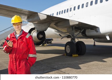 Aircraft engineer with CB radio standing in front of a commercial airliner