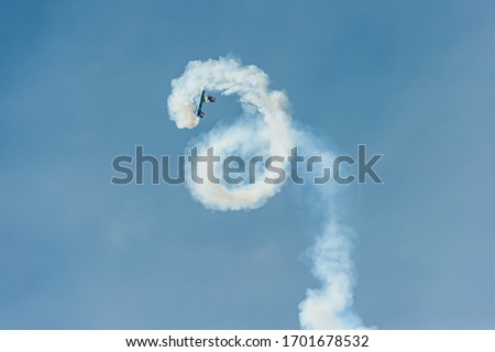 Similar – Red plane with propeller flying upward with white smoke