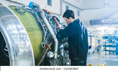 Aircraft Maintenance Mechanic Inspecting and Working on Airplane Jet Engine in Hangar - Powered by Shutterstock