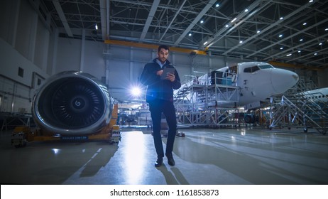 Aircraft Maintenance Mechanic Inspecting And Working On Airplane Jet Engine In Hangar