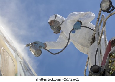 Aircraft Painting And Sandblasting.  Spray Painting, Airplane Wing. Worker In Coverall Using Airbrush. Passenger Aircraft During Maintenance And Painting.