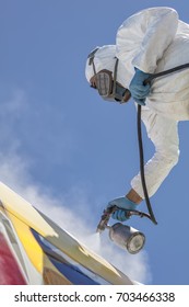 Aircraft Painting And Sandblasting.  Spray Painting, Airplane Wing. Worker In Coverall Using Airbrush. Passenger Aircraft During Maintenance And Painting.