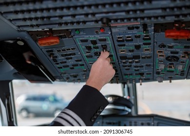 Aircraft Pilot Operating Overhead Panel Of Airplane Flight Deck