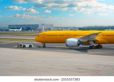 Aircraft push the tow tractor before starting the engines and taxiing, side view - Powered by Shutterstock