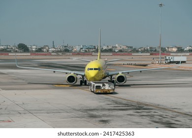 Aircraft pushes the tow tractor before starting the engines and taxiing, front view - Powered by Shutterstock