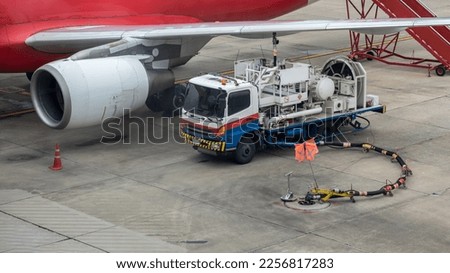 Aircraft refueling by high pressure fuel supply truck. Refueling operation of large widebody passenger aircraft standing on airport's parking place . Refueling of the airplane before flight.