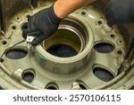 Aircraft Wheel NDT Inspection Using Ultrasonic Testing Equipment. Aviation maintenance technician performs non-destructive testing of landing gear component