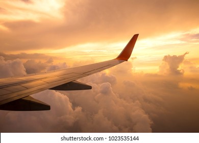 Aircraft wing on the clouds of sunset ,flying traveling background - Powered by Shutterstock