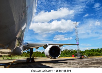 Aircraft(airplane) Parking For Maintenance Before Flight And Blue Sky With Clouds In Background.Aircraft Parking In Front Of Aircraft Hangar For Maintenance.