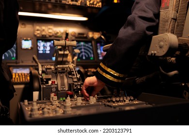 Aircrew Member Using Control Panel Command On Dashboard Navigation To Fly Ariplane In Cockpit. Female Airliner Flying Plane In Cabin With Power Engine And Switch Lever. Close Up.