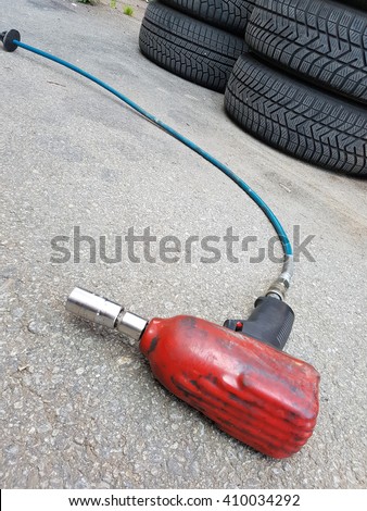 Airgun wrench and tires on the ground at automotive service center