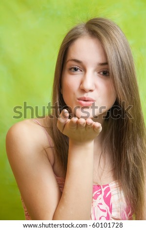 Air-kissing long-haired teen girl over green background