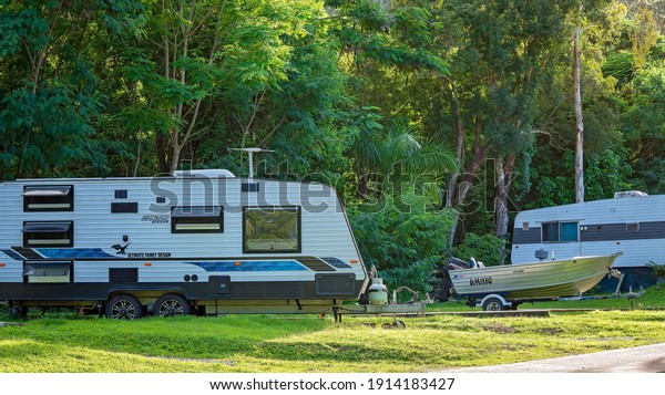 Airlie Beach, Queensland, Australia -\
February 2021: Holidaymakers enjoying their carefree caravan and\
boating lifestyle in a tropical tourist\
park