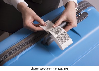 Airline Check In Luggage Tag Being Attached To A Suitcase