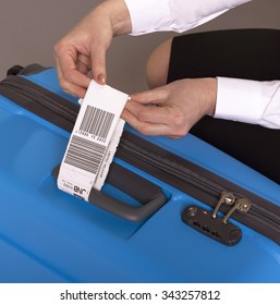 Airline Check In Luggage Tag Being Attached To A Suitcase