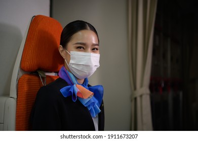 Airline Flight Crew Attendant Wearing Face Mask During Travel Trip To Prevent Coronavirus On Airplane Cabin. Covid-19 Outbreak Prevention In New Normal Airline Business Concept During Virus Epidemic.