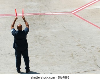 Airline Ground Crew Directing An Aircraft To The Airport Gate