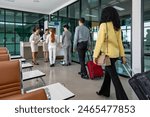 Airline ground staff is using metal scanner for security check every passengers in airport departure terminal for safety protocol before boarding into plane