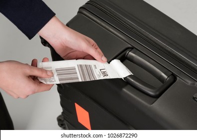 Airline Luggage Security Tag Being Attached To A Travellers Black Suitcase