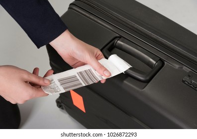 Airline Luggage Security Tag Being Attached To A Travellers Black Suitcase