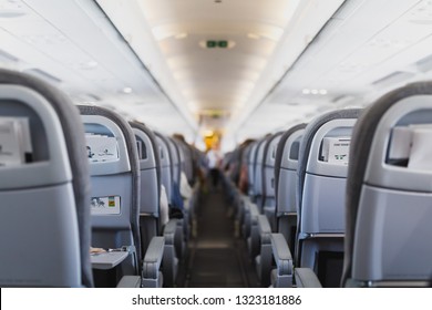 airline passenger seats and aisle in airplane cabin