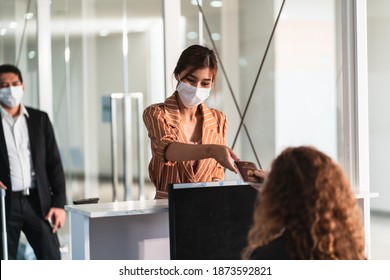 Airline Passenger Wear Face Mask At  Check In Counter In Airport With Staff Wear Face Shield. New Normal Concept Of Travel After Covid-19 Pandemic