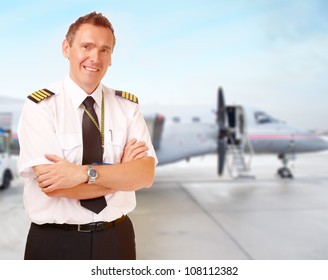 Airline Pilot Wearing Uniform With Epaulettes With Passenger Aircraft In Background