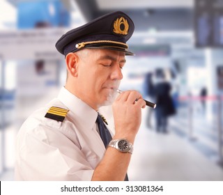 Airline Pilot Wearing Uniform With Epaulettes Smoking Electronic Cigarette.